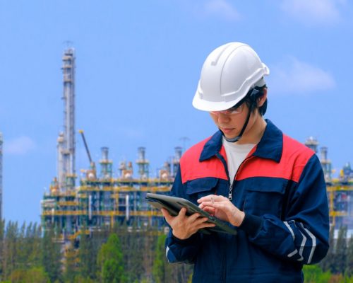 young-asian-engineer-using-digital-tablet-to-working-his-job-with-blurred-background-of-oil-refinery_t20_wkWBee